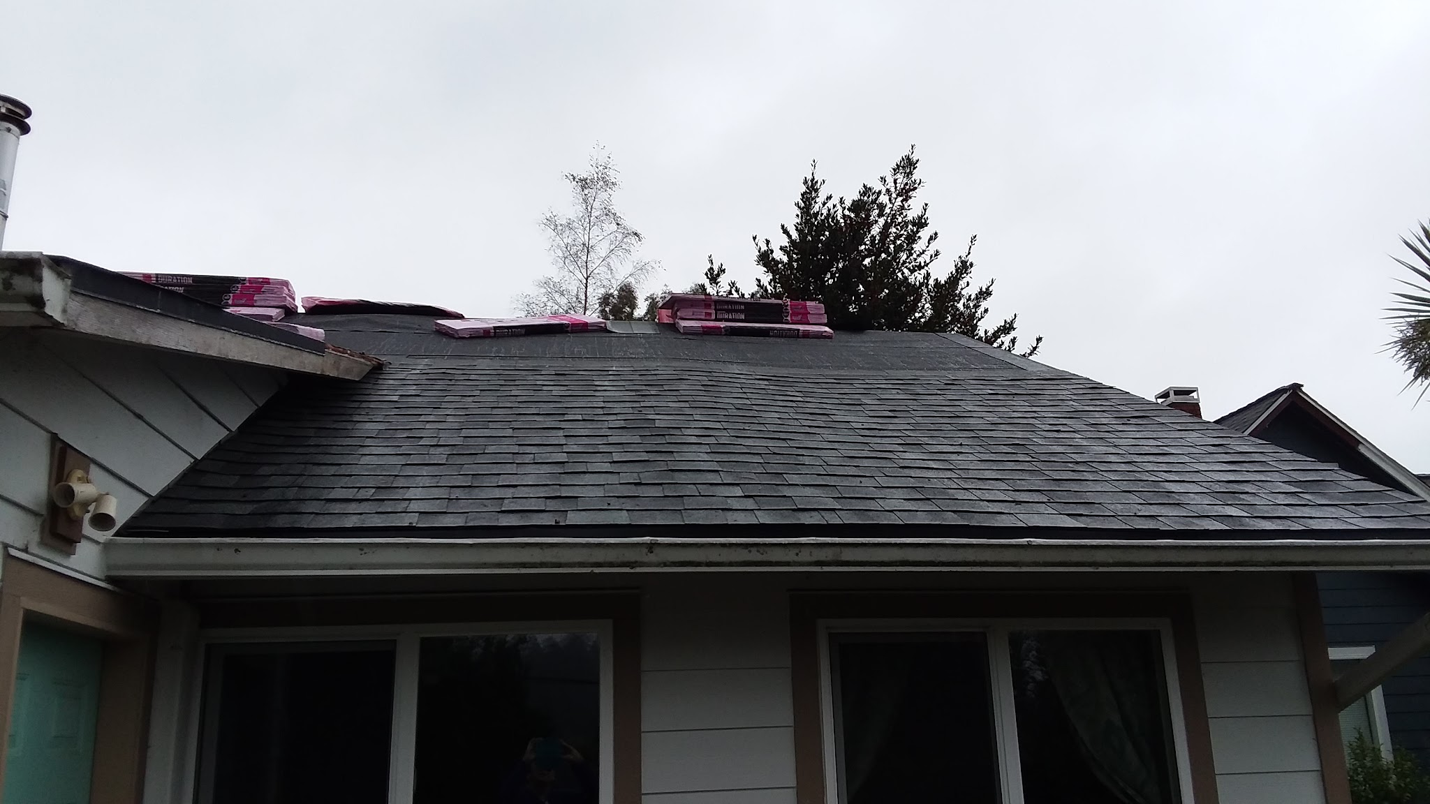 Shingle bundles staged on a roof deck during a mid-project reroof