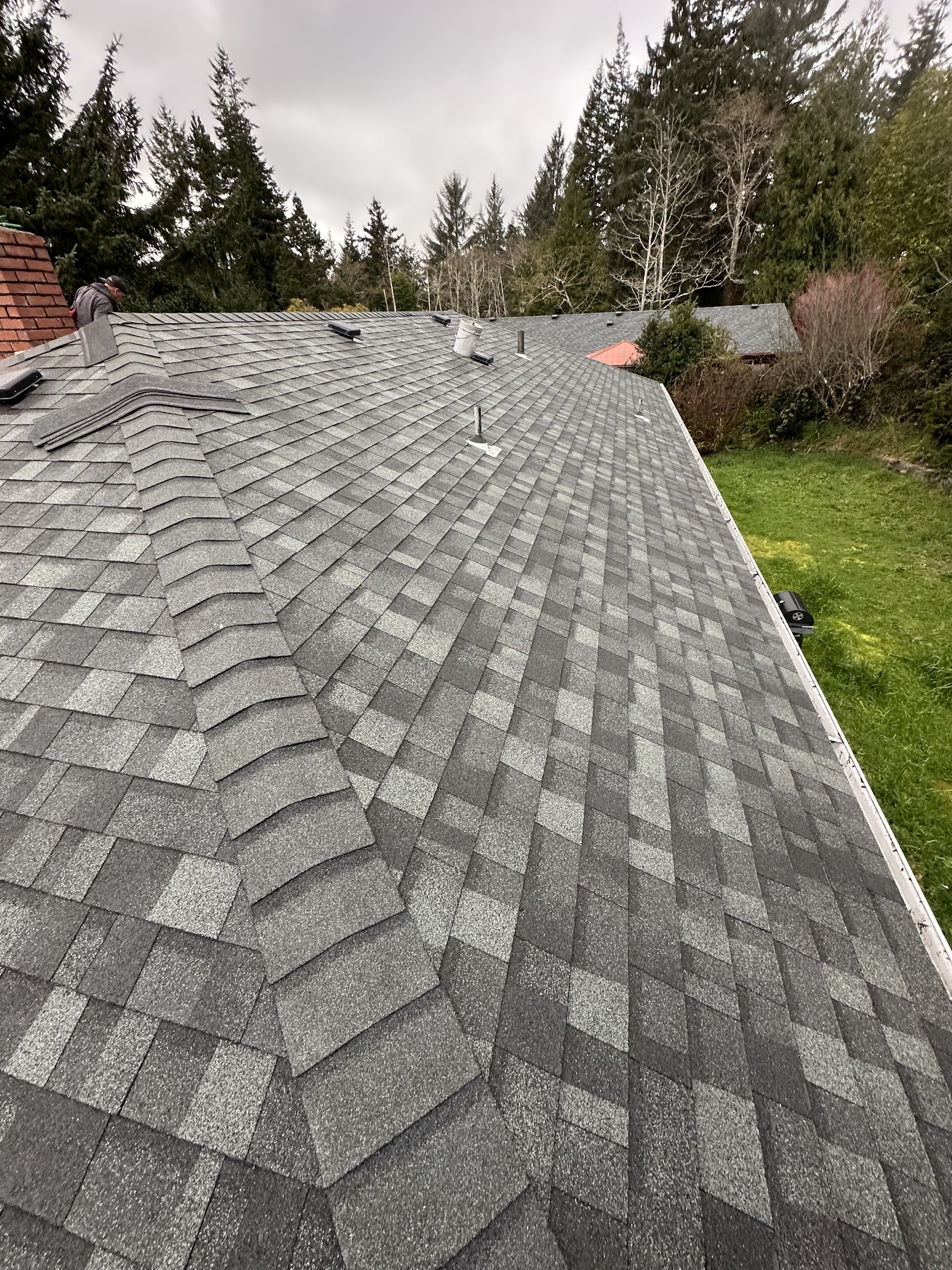 Crew member mid tear-off during a roof replacement