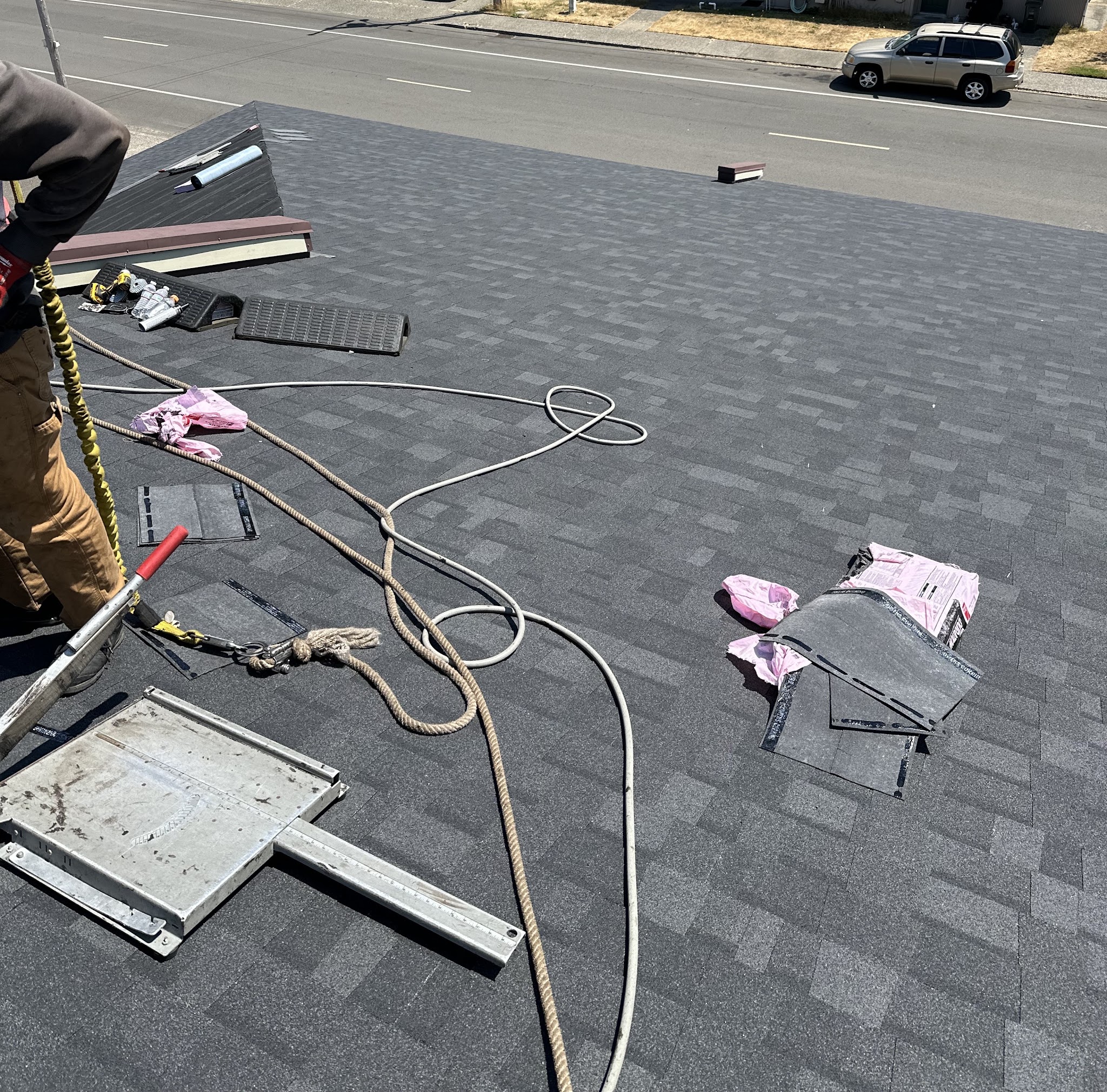 Tools, safety line and materials staged on a flat commercial roof mid-job